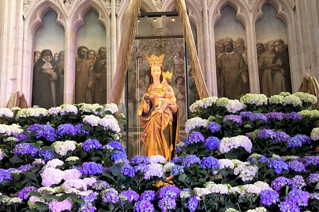 'Maria, Oorzaak onzer blijdschap' tussen de bloemen op de Kroningsfeesten in Tongeren. Mariabeeld 'Oorzaak onzer blijdschap' tussen de bloemen op de Kroningsfeesten in Tongeren.