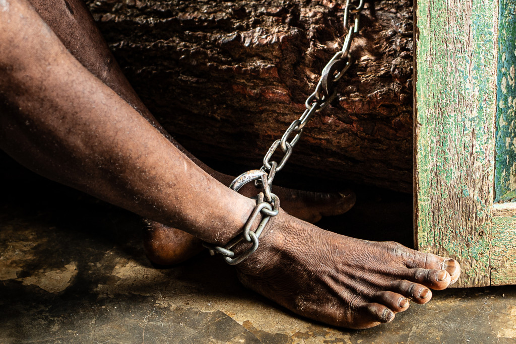 De geestelijke gezondheidszorg in Guinée Conakry (West-Afrika) laat nog vaak te wensen over. Blote voet aan een ketting in een lemen huis in Guinée Conakry, West-Afrika.