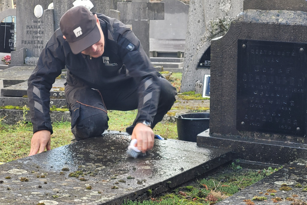 Jozef Petit van Monumentenwacht reinigt een grafzerk. Jozef Petit van Monumentenwacht reinigt een grafzerk.