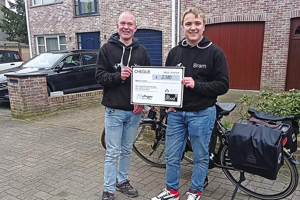 Yarle Verbeeck (links) en Bram Covens met de cheque die ze vorig jaar konden overhandigen aan Argos Assistance Dogs in Wijnegem. © Yarle Verbeeck
