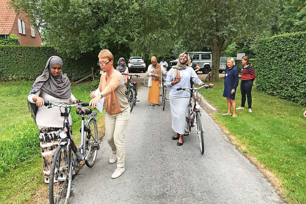 Vrijwilligers van Karibu in Anzegem leren nieuwkomers fietsen. © Karibu Anzegem