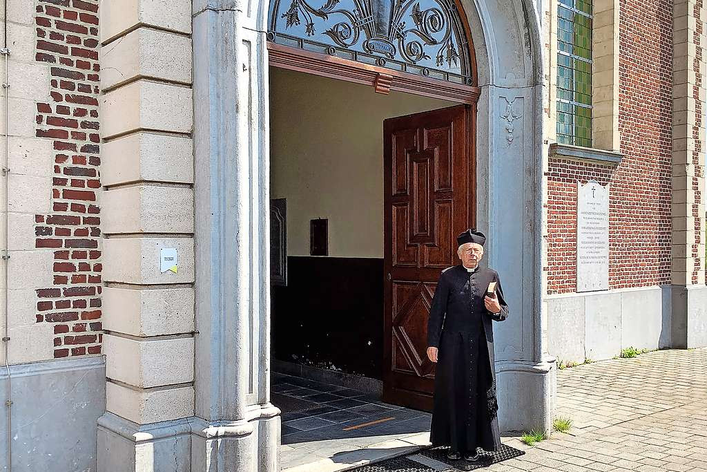 Luc Van Liedekerke leidt in de kerk in Strijtem bezoekers rond als pastoor Cuylits. © Jan De Bodt