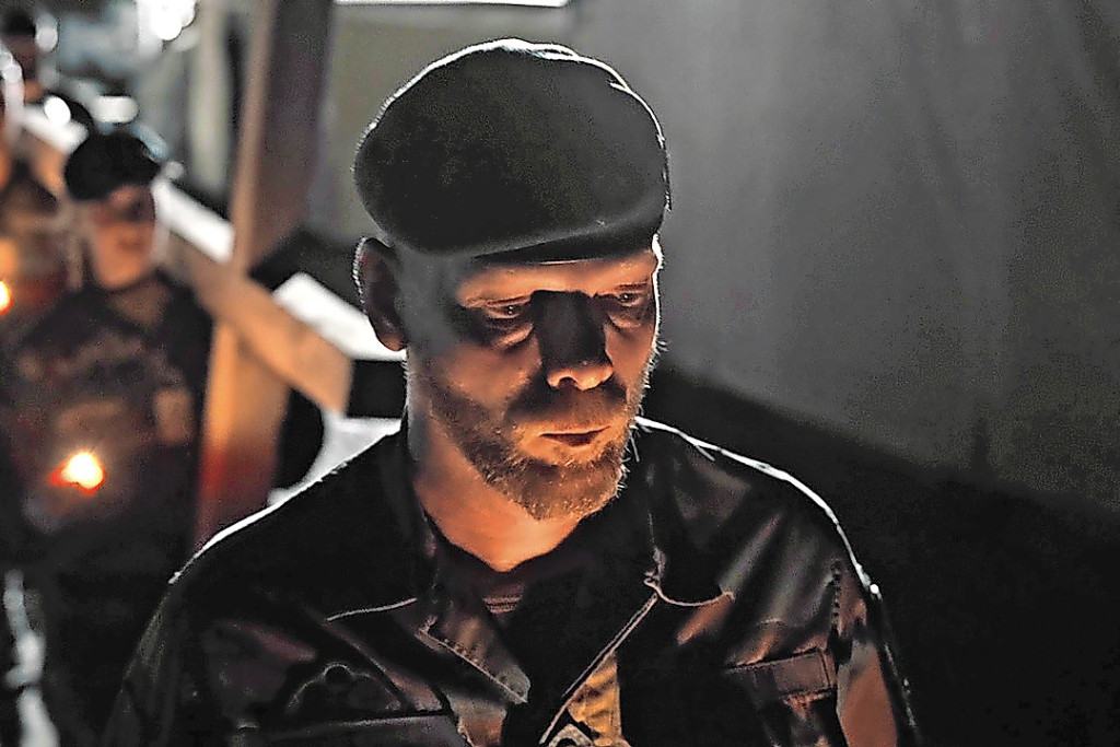 Padre Hans begeleidt de challenge met het kruis. © VRT