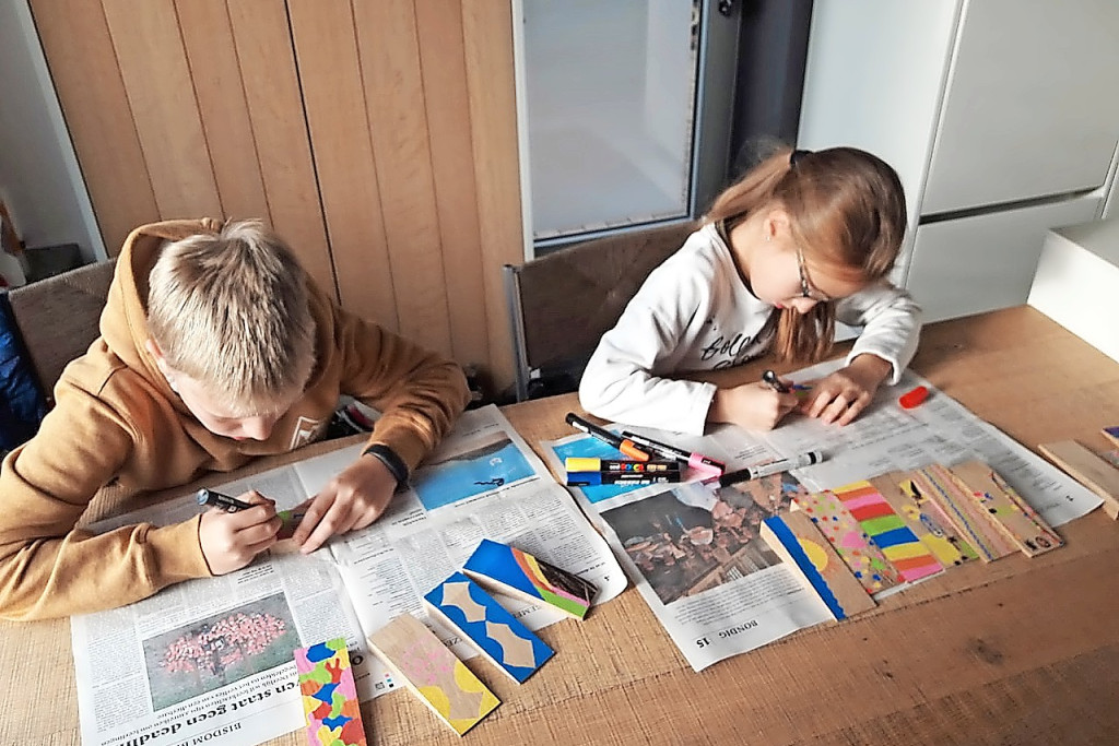 Kinderen helpen de houten peggen versieren en geven ze aldus een persoonlijke touch. © Riet Tack