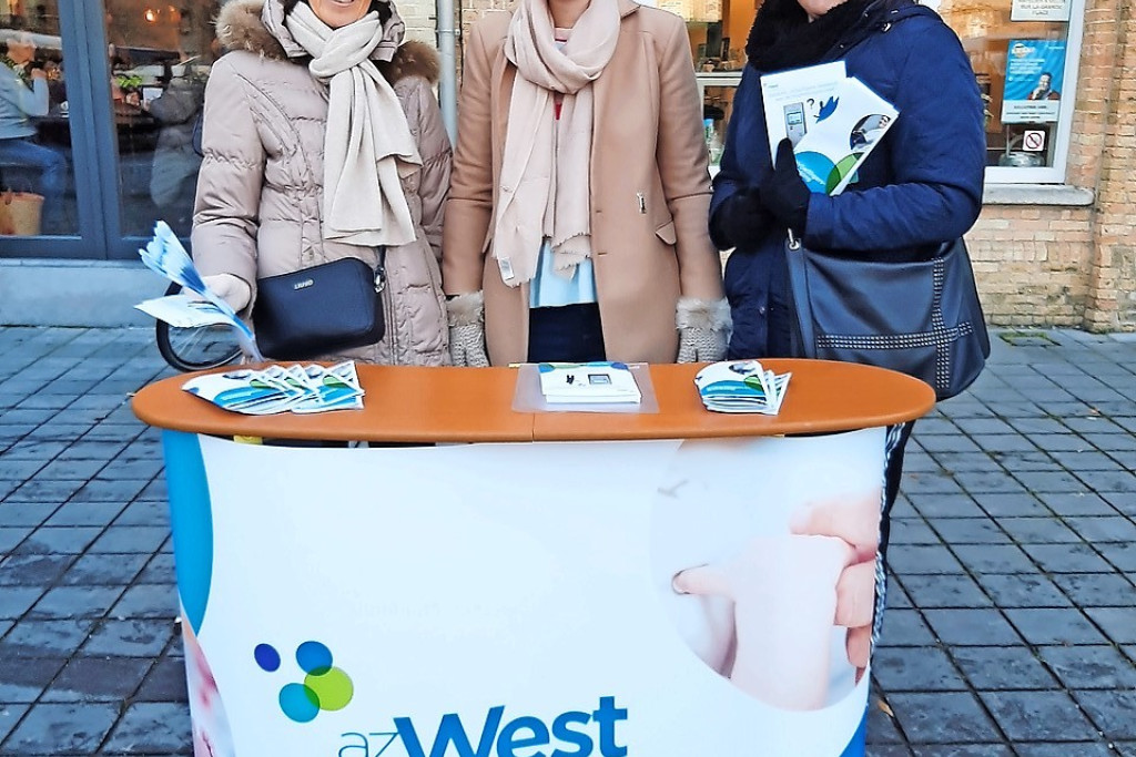 Op de markt in Veurne werft Bieke Roose (midden) nieuwe vrijwilligers. © Bieke Roose
