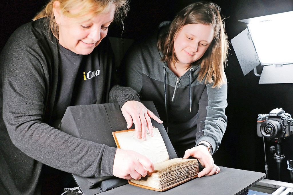 Met de hulp van vrijwilligers worden de boeken zorgvuldig en pagina per pagina gefotografeerd. © July Van Malderen