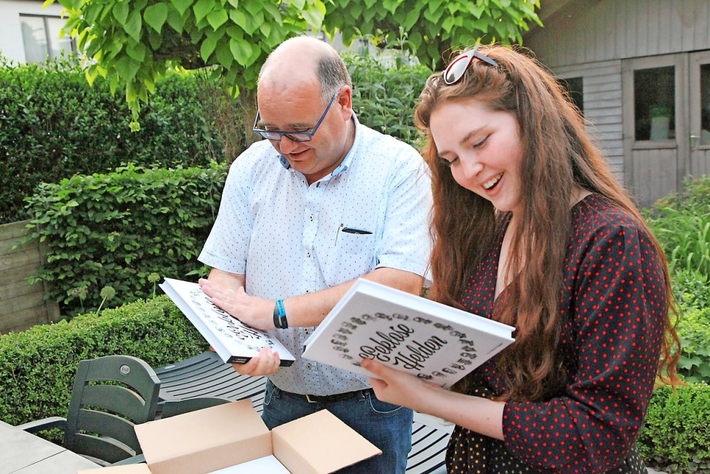 Marc Van Hulle en Noor De Dapper kijken de eerste exemplaren van het boek Eeklose Helden in. © Steven De Dapper
