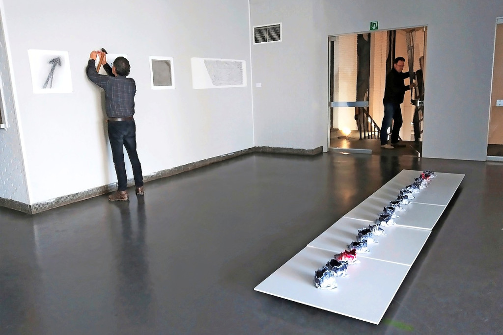 Vrijwilligers installeren met zorg en overleg de kunstwerken in het weldra te slopen cultuurcentrum in Zolder. © ART.27