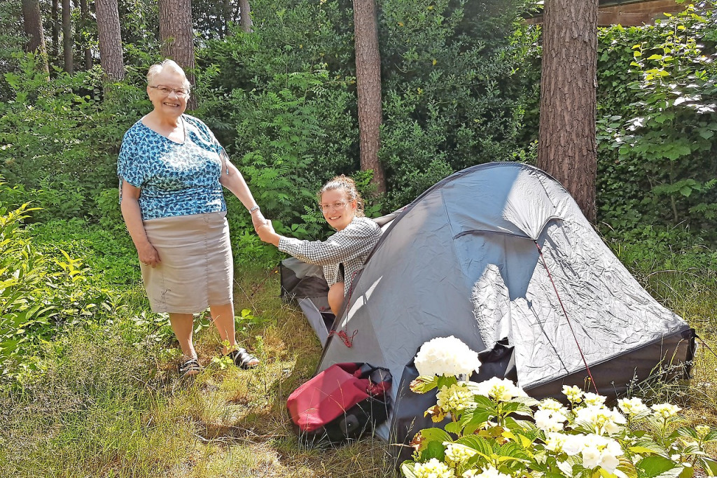 Oma Frieda Goolaerts glundert bij het bezoek van kleindochter Eva Plasschaert, al verblijft ze in haar tent. © Ilse Van Halst