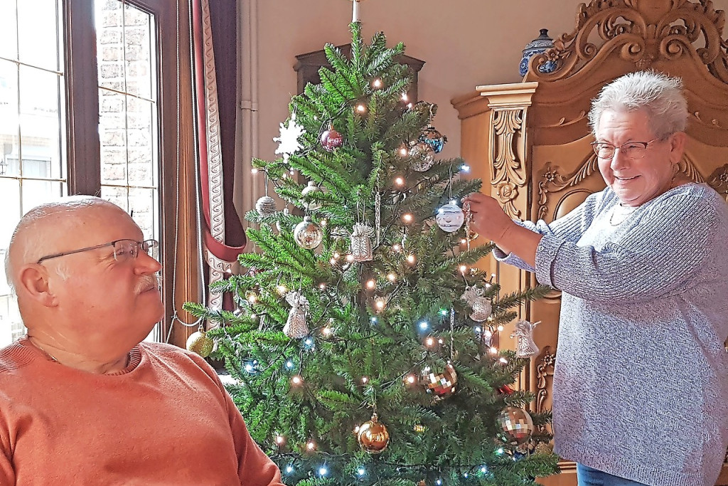 Luc Camps en Josephina Bosmans vinden troost bij de kerstboom en het kerstdorp op hun dressoir. © Ilse Van Halst