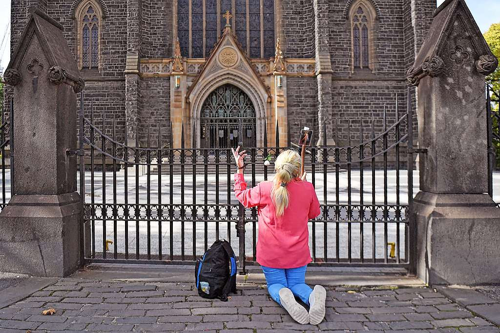 Een vrouw bidt tijdens de lockdown aan Saint Patrick’s Cathedral in Melbourne. © Belga Image Een vrouw bidt tijdens de lockdown aan Saint Patrick’s Cathedral in Melbourne. © Belga Image