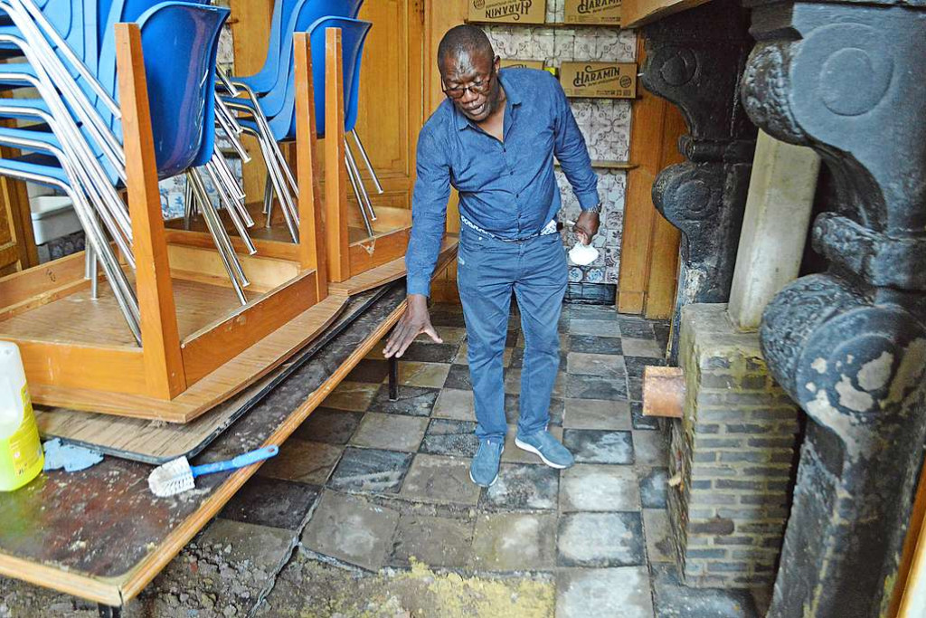 Deken Stanislas Kanda toont hoe hoog het water stond in de dekenij in Verviers. © Erik De Smet