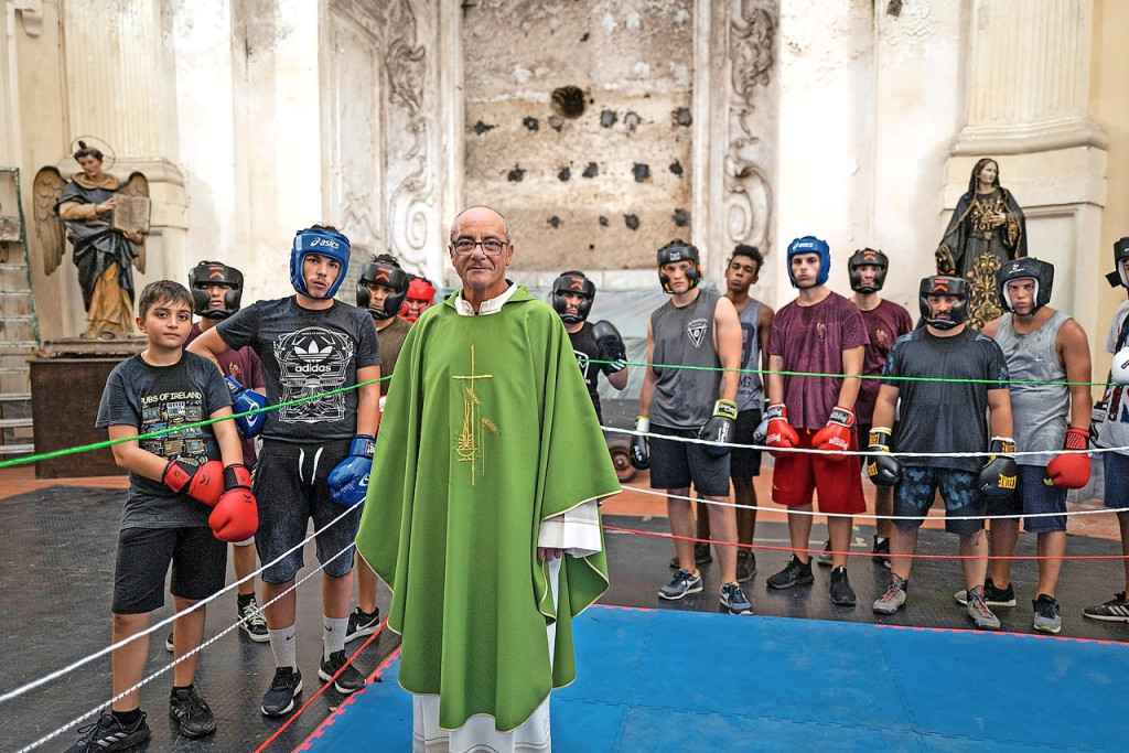 Priester Antonio Loffredo in de boksring die hij in zijn kerk liet installeren. © Roberto Salomone Priester Antonio Loffredo in de boksring die hij in zijn kerk liet installeren. © Roberto Salomone