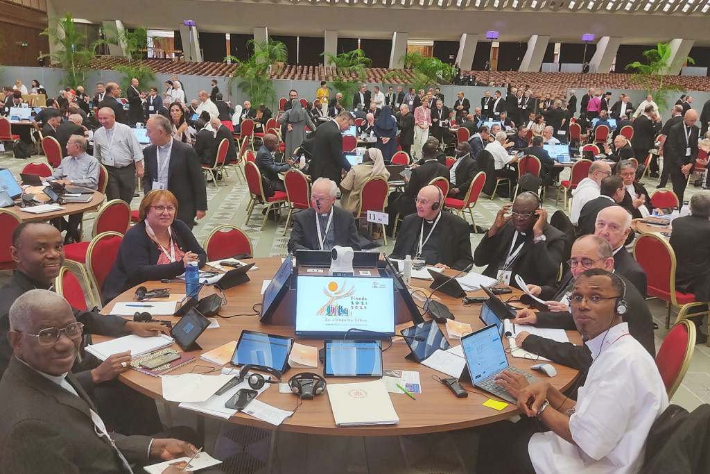 ronde synodetafel in volle Paulus VI-zaal, oktober 2023, eerste sessie van de bisschoppensynode over synodaliteit plaats. Aan de tafel op de voorgrond zit kardinaal Jozef De Kesel.