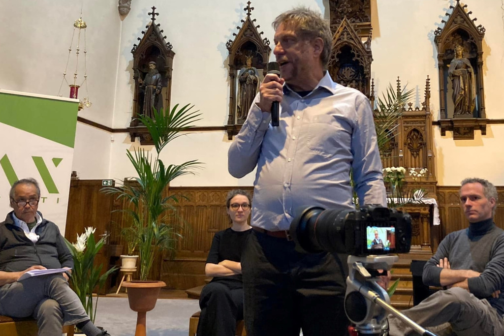 Directeur Stefan Nieuwinckel van Pax Christi Vlaanderen met op de achtergrond (van links naar rechts) gewezen vrt-journalist Tjhoi Ng Sauw, bewegingsmedewerkster Merel Selleslach en defensie-expert Jorge Hersschens van de Universiteit Antwerpen