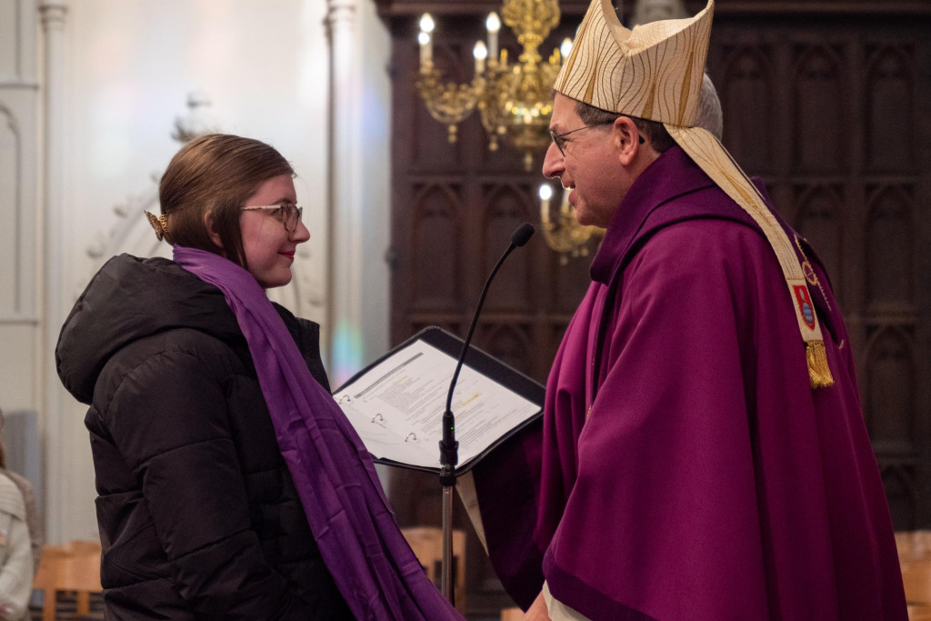 Overhandiging van de paarse sjaal