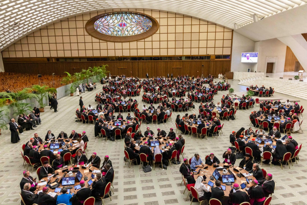 Zicht op de Paulus VI-zaal van het Vaticaan, waar de deelnemers aan de synode gegroepeerd zaten aan ronde tafeltjes.