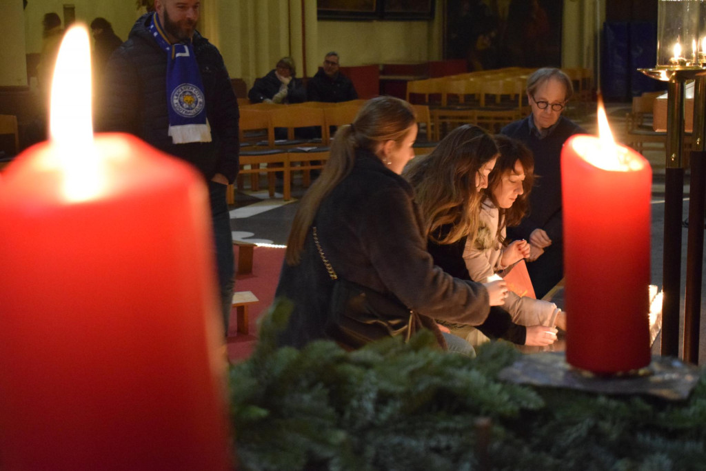Voorbijgangers steken kaarsjes aan op Nightfever.