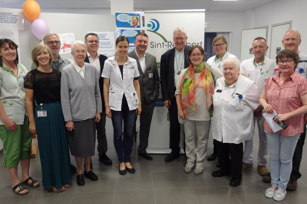 De Gentse bisschop Luc Van Looy samen met ziekenhuispastor Els Margodt en collega's op de foto