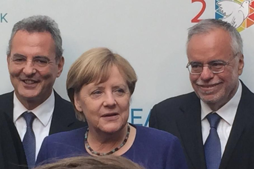 Bondskanselier Angela Merkel tussen Andrea Riccardi (rechts) en voorzitter Marco Impagliazzo (links) van Sant'Egidio
