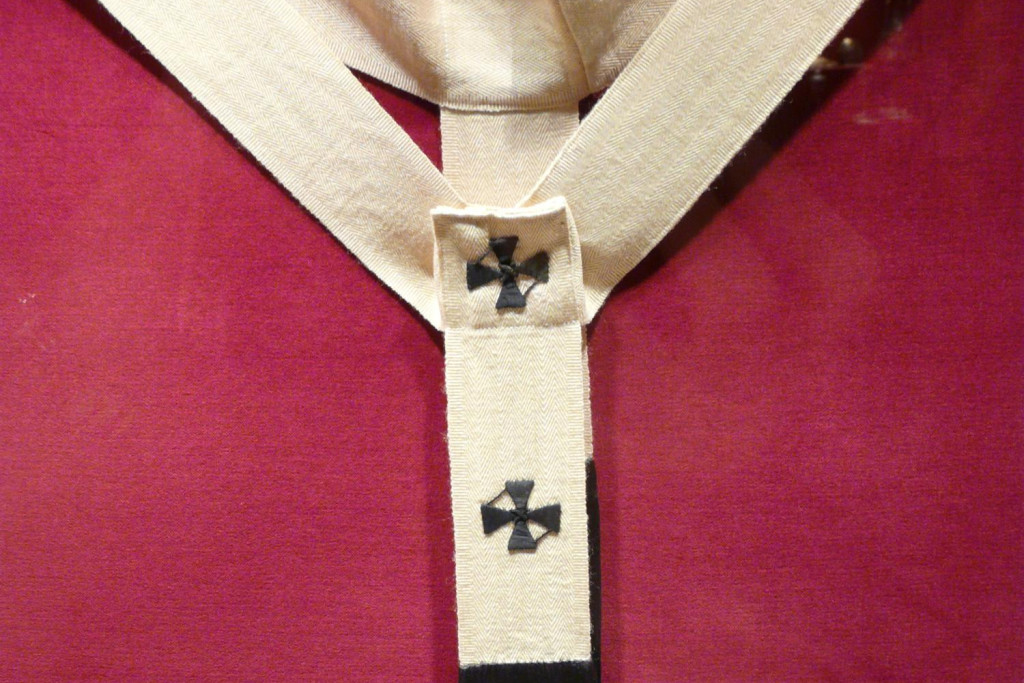 Een pallium is een witte, wollen band die over de schouders wordt gedragen. Een pallium is een witte, wollen band die over de schouders wordt gedragen.