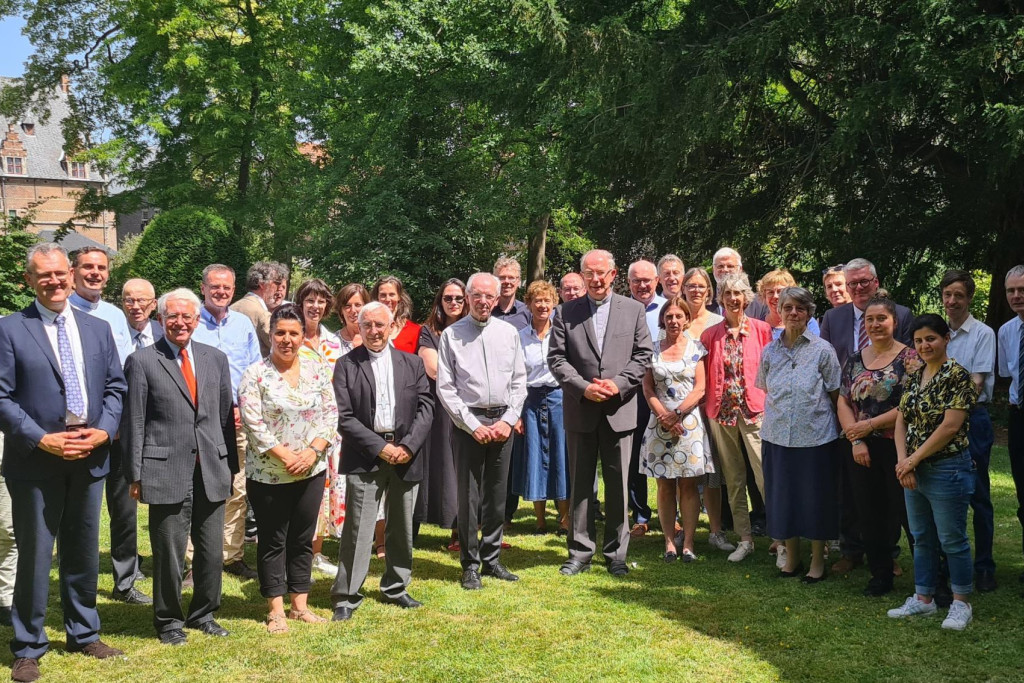 De jarige kardinaal Jozef De Kesel met de leden van de bisschopsraad en het personeel van het aartsbisdom in de tuin van het bisschopshuis in Mechelen