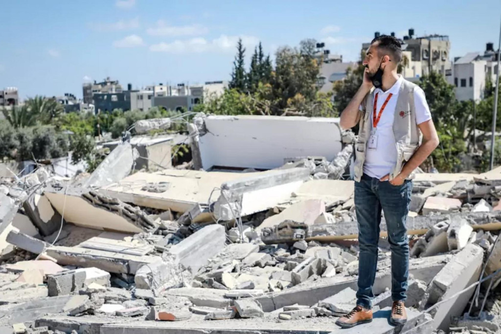 Een medewerker van Caritas Jeruzalem meet de schade op van bombardementen in Gaza.