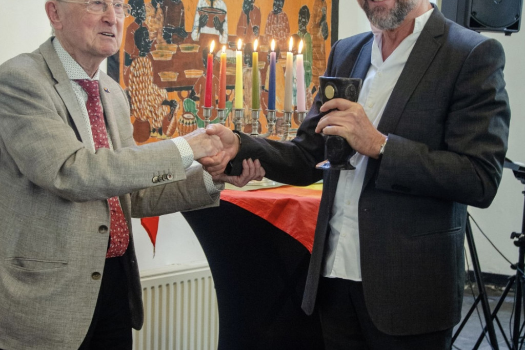 Priester Jan Veldt reikt de Graalbokaal Award uit aan Willy Bombeek.
