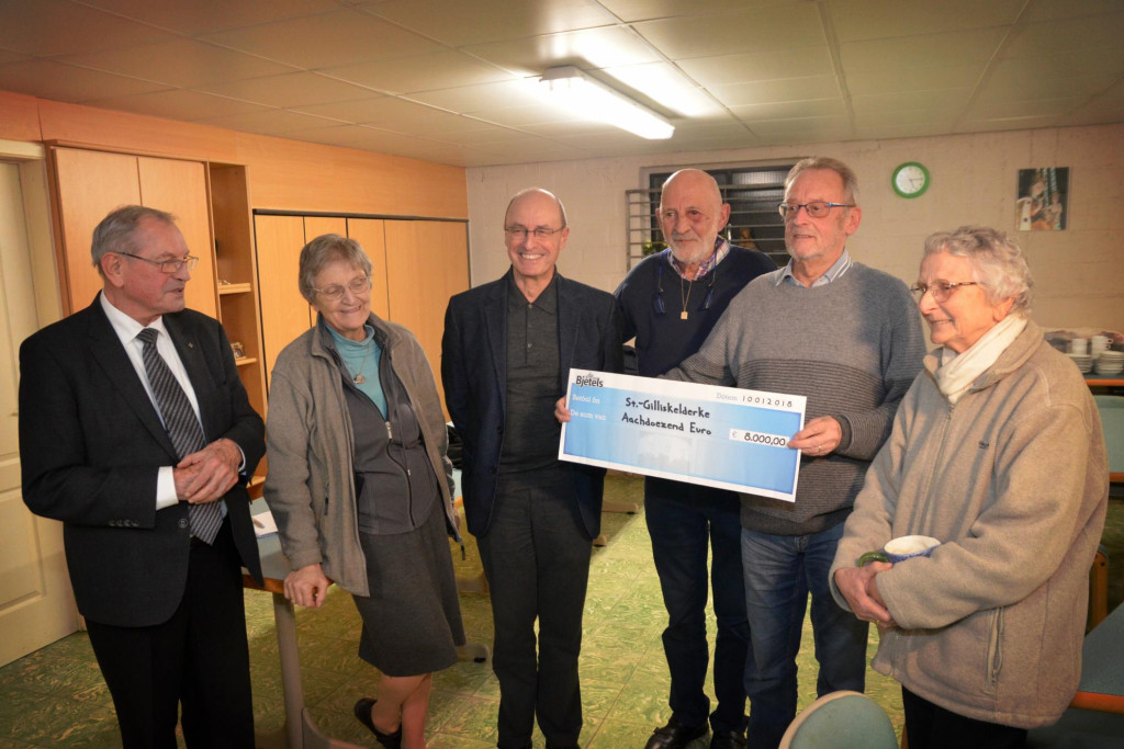 Deken Rik Palmans en Lea en Philo van het Sint-Gilliskelderke nemen de cheque van De Bjetels in ontvangst