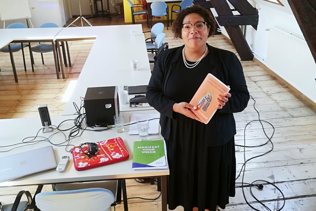 Bénédicte Kusendila, met een boek over Sint-Franciscus in de hand en het Manifest voor Vrede